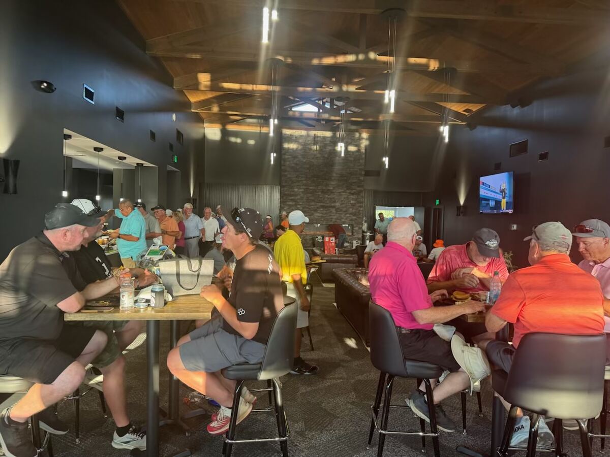 Golfers gathered around tables in the Woodland Golf Club clubhouse for food after the round