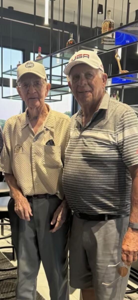 Donzil Hall standing with Terry Howell in the clubhouse at the golf outing