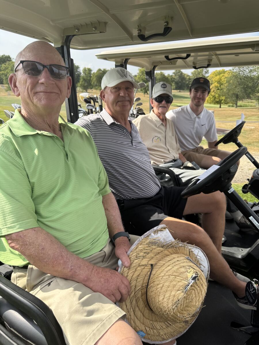 A foursome of golfers seated in golf carts before heading out to play